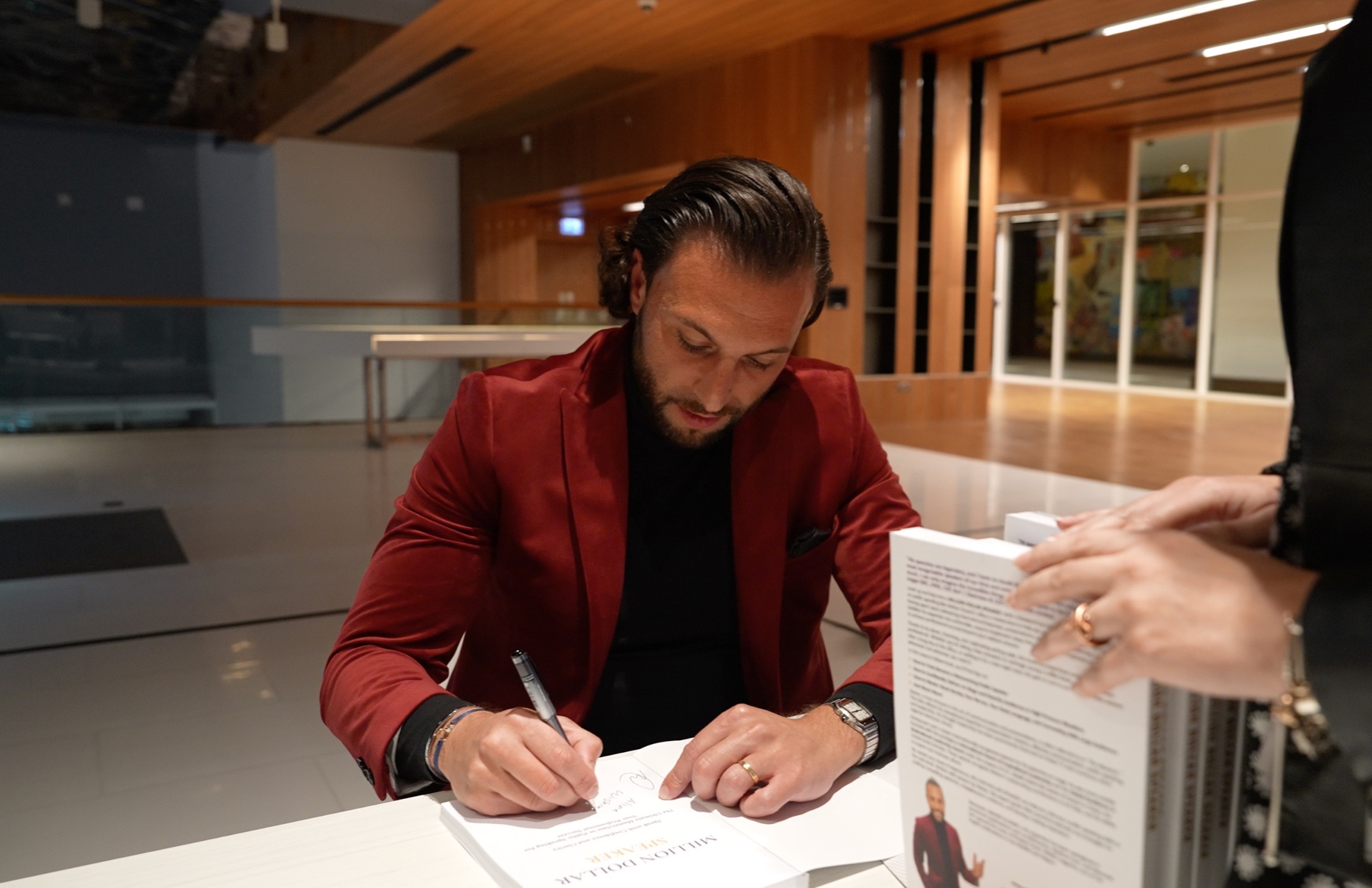 Maher Elusini signing a copy of Million Dollar Speaker